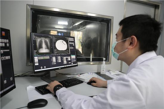 JXF吉祥坊体育医院医务人员在移动CT车上进行操作(摄影:张宾)