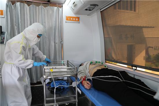 JXF吉祥坊体育医院医务人员在移动体检车上进行心电图检查(摄影:张宾)