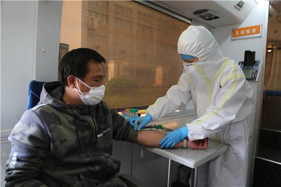 JXF吉祥坊体育医院医务人员在移动体检车上进行血常规检查(摄影:张宾)