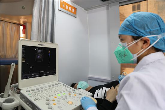 JXF吉祥坊体育医院医务人员在移动体检车上进行B超检查(摄影:张宾)